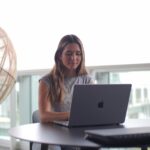 A woman focusing on her laptop, studying in an outdoor setting.