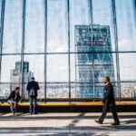 Business professionals in a modern office against a London skyline view.